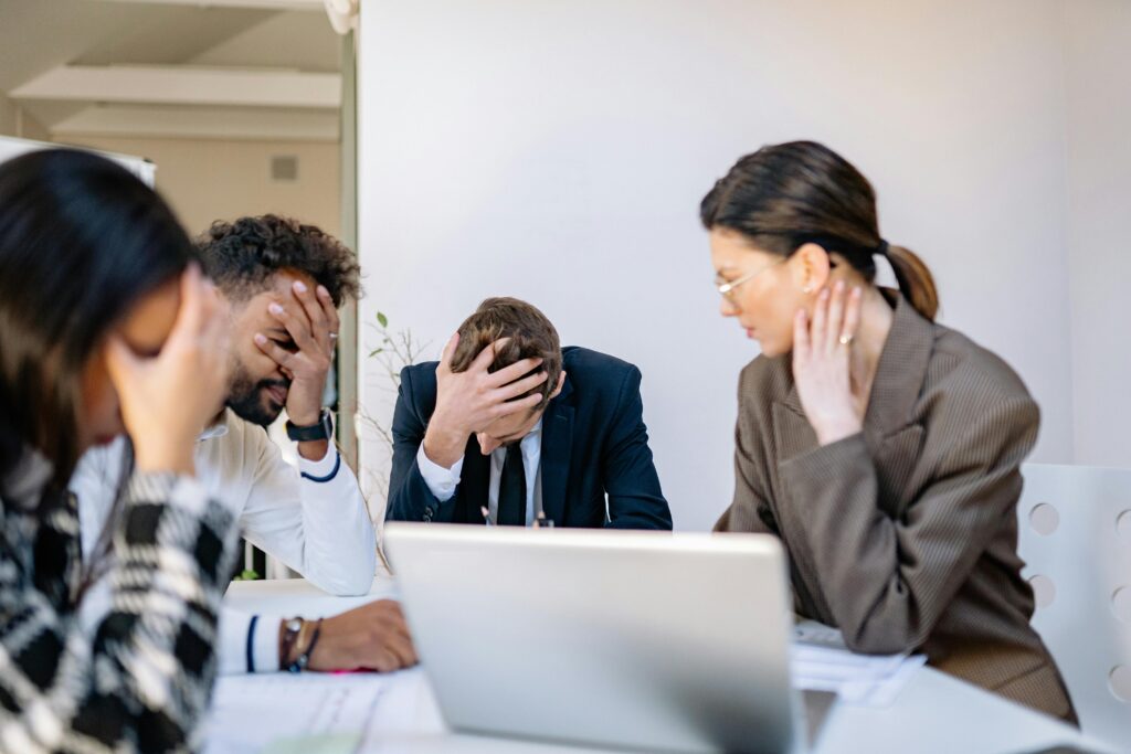 A group of stressed business professionals in an office setting, overwhelmed by work.